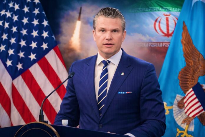 US Defence Secretary Pete Hegseth speaks as US and Iranian flags appear in background