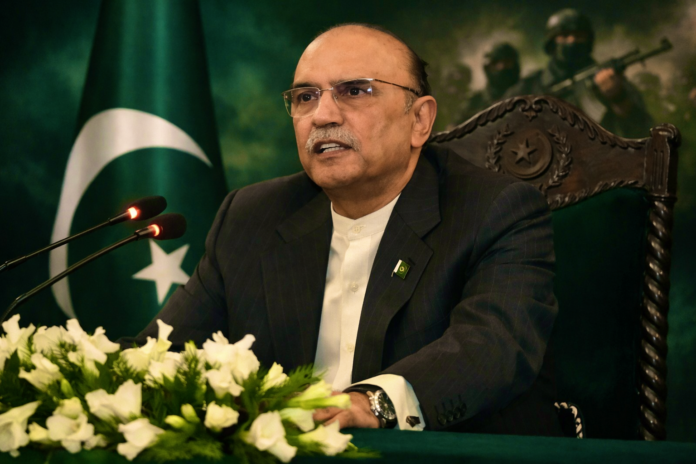 President Asif Ali Zardari addressing media with Pakistan flag in background.